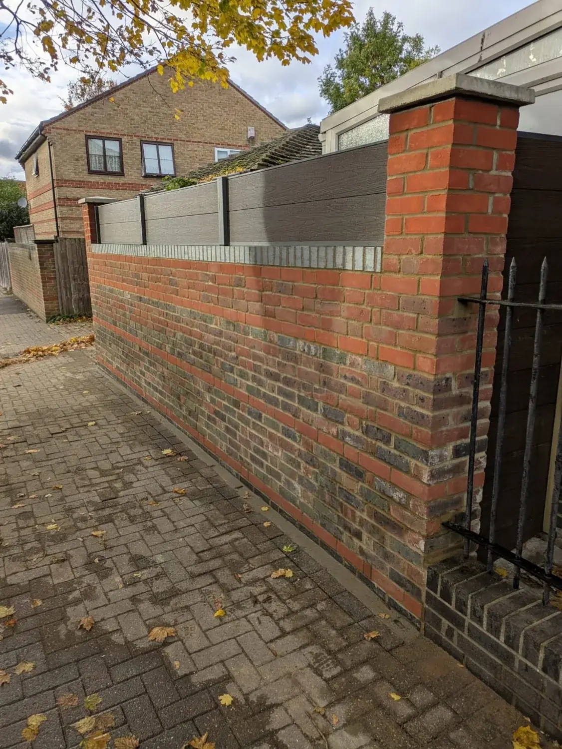 Brick boundary wall with grey fence panels