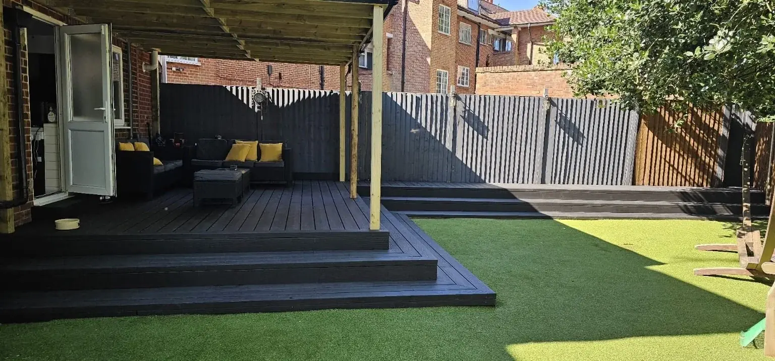 Covered composite decking with outdoor seating beside a lawn
