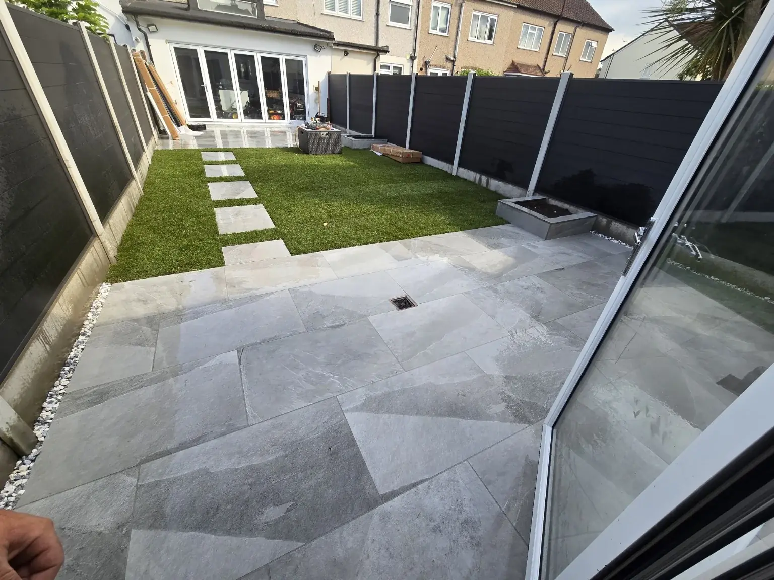 Grey stone patio with stepping stones across a lawn